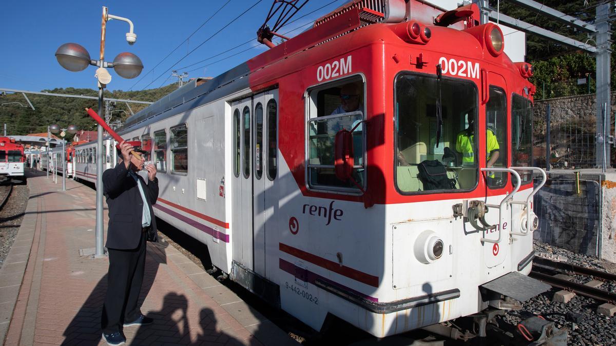 Un revisor avisa de la salida del tren en la estación de Cotos (Madrid).