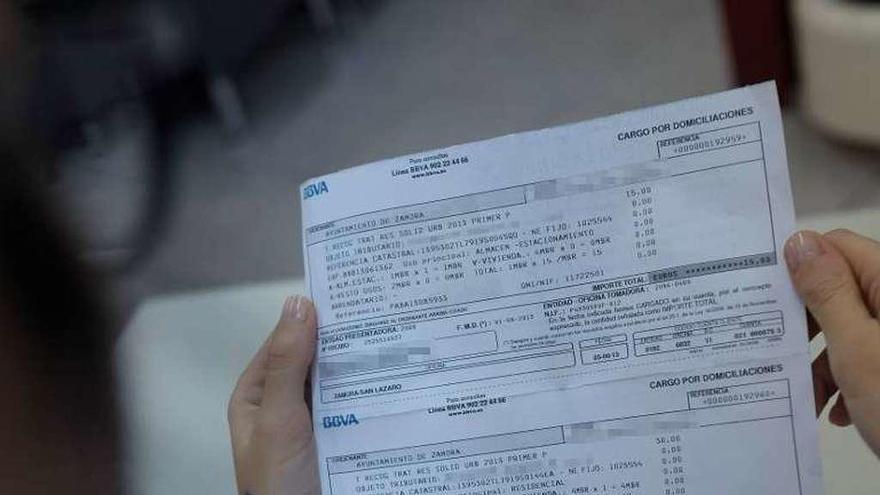 Un contribuyente examina su recibo domiciliado.