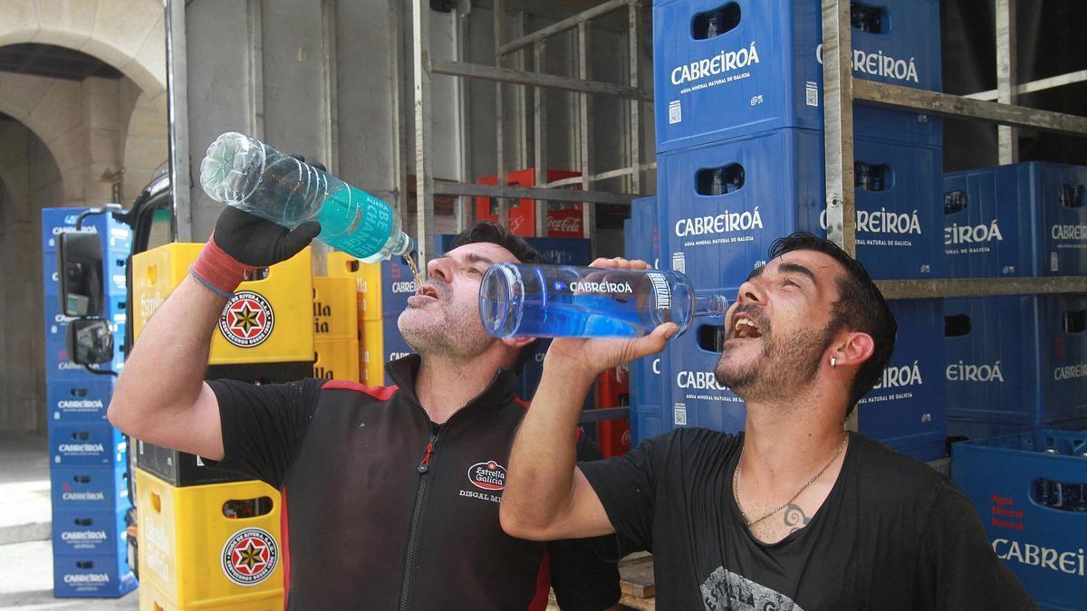 Dos trabajadores bebiendo agua durante su jornada.