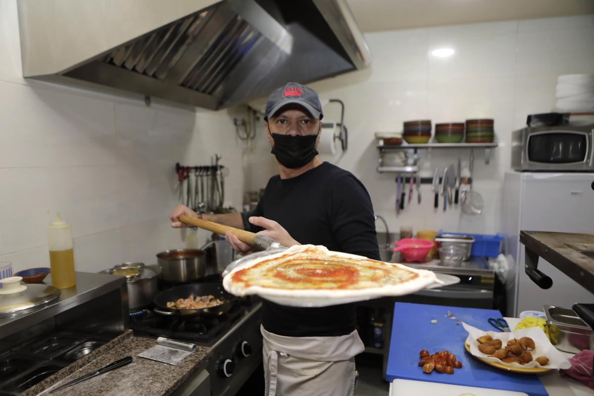Cossimo Rizzo mete una pizza en el horno, en El Entrego.
