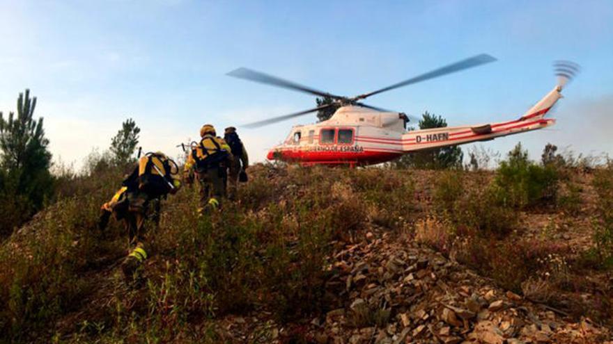 Tres bomberos se dirigen a un helicótero en Quiroga // BrifLaza