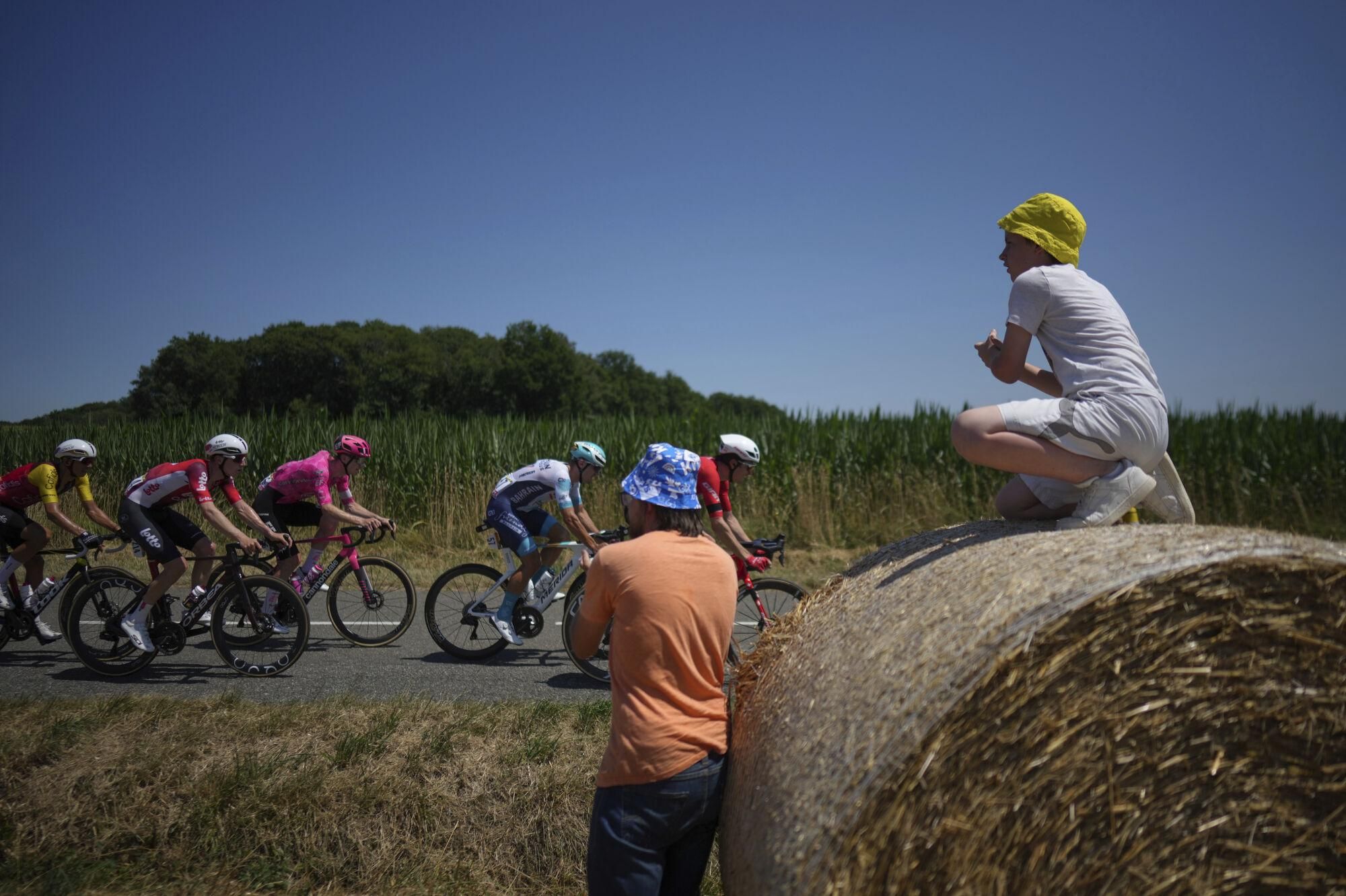 Spectators watch the breakaway group during the twelfth stage of the Tour de France cycling race over 180.6 kilometers (112.2 miles) with start in Auch and finish in Hautacam, France, Thursday, July 17, 2025. (AP Photo/Thibault Camus)