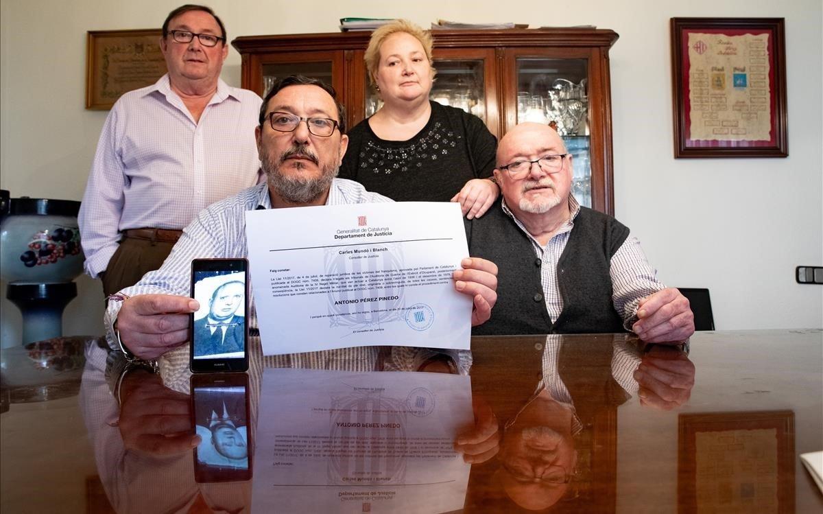 Antonio, Fernando, Carmen y Francisco Pérez (de izquierda a derecha) muestran el diploma de rehabilitación de su padre.