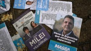 Propaganda electoral de Javier Milei y Sergio Massa en el suelo en una calle de Buenos Aires.