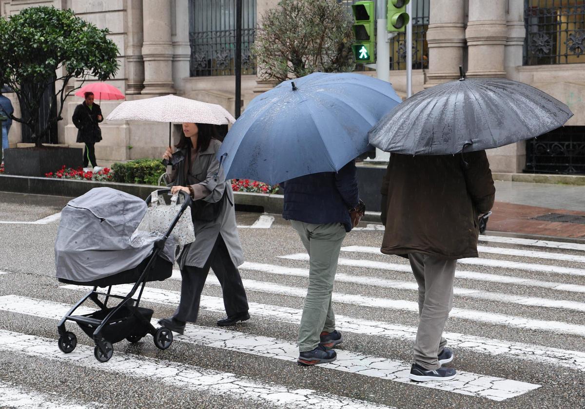 Viandantes cubiertos con paraguas en el centro de Vigo.