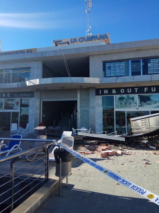 El viento derriba un cartel de grandes dimensiones sobre la terraza de un centro comercial en Orihuela Costa sin causar víctimas