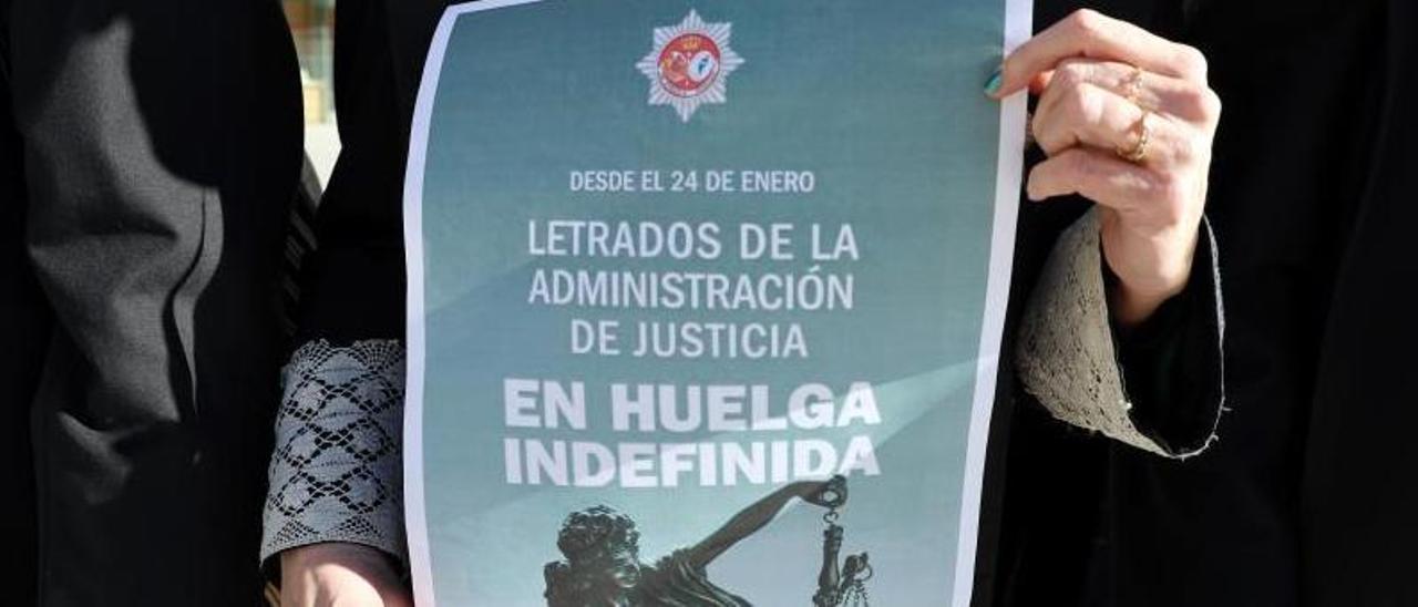 Una letrada judicial sostiene un cartel de la huelga en una de las concentraciones de Vigo.