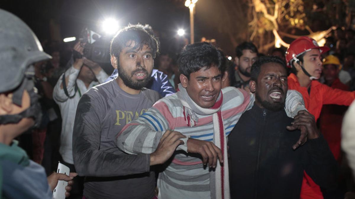 Un hombre llora desesperado buscando a su hermana, desaparecida en la fábrica, este sábado en Dacca (Bangladés).