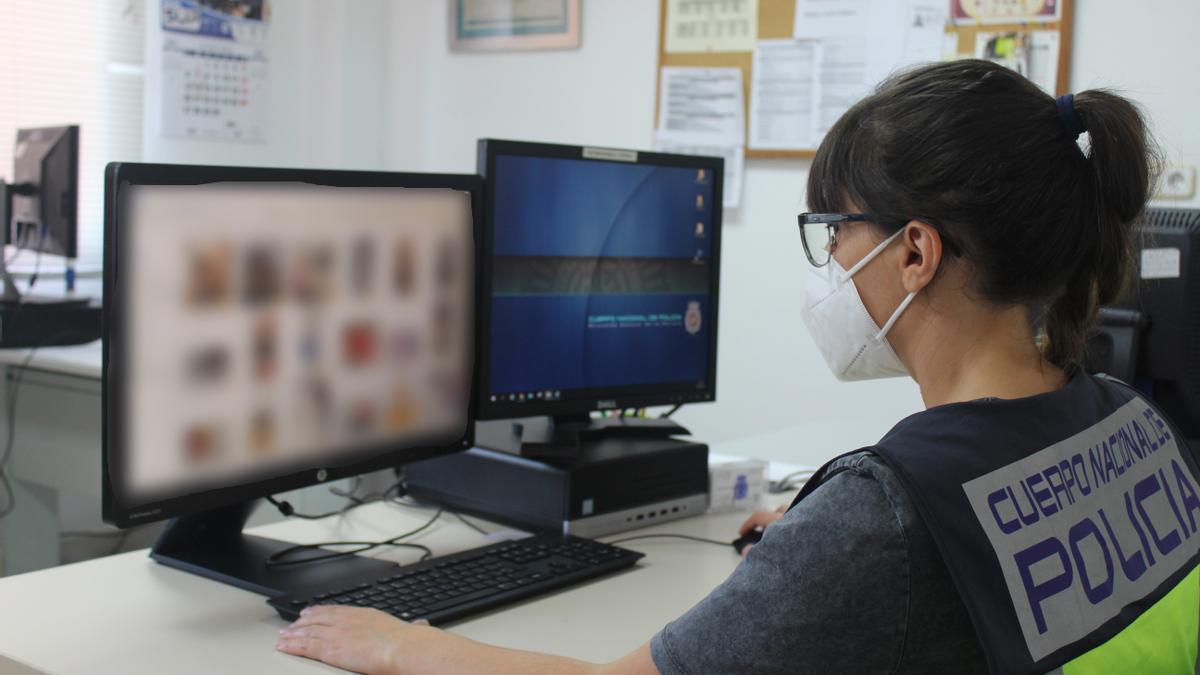 Una policía examina un ordenador en una operación contra la pornografía infantil.