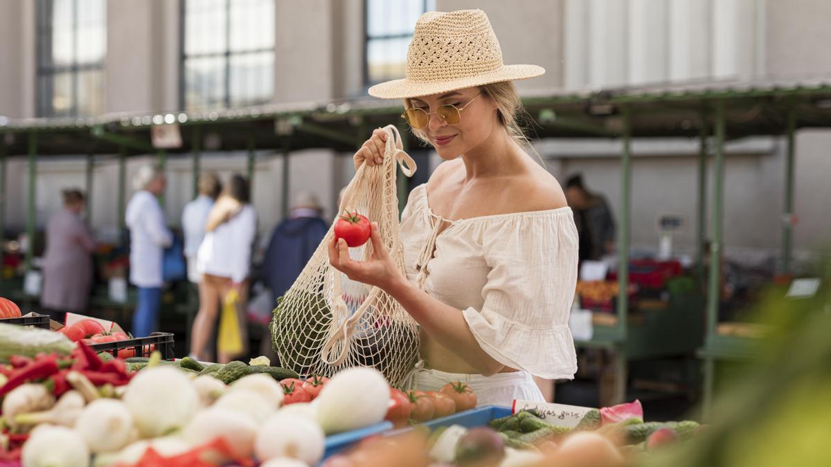 Mujer con un tomate en un mercado