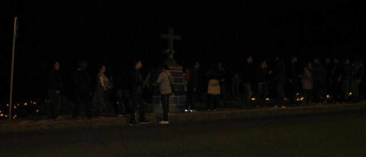 El grupo de paseantes ante la cruz de piedra, en una parada de su recorrido a pie por el curso de la Línea 8 de Guaguas Municipales.