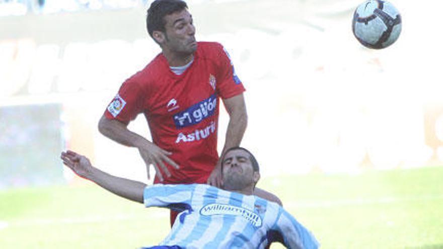 Barral disputa el balón con el defensa del Málaga Juanito.