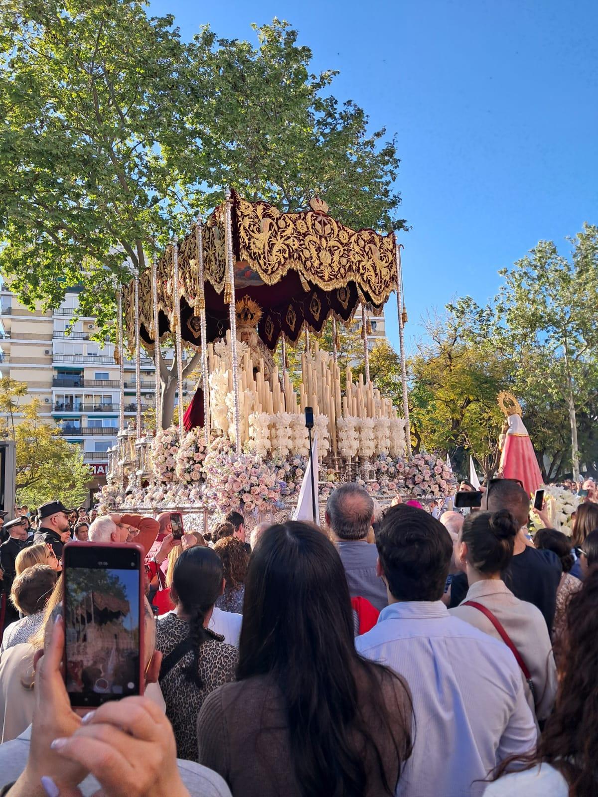 El paso de la Virgen del Rosario ante la imagen de la Santina que saca a la calle el Centro Asturiano de Sevilla.