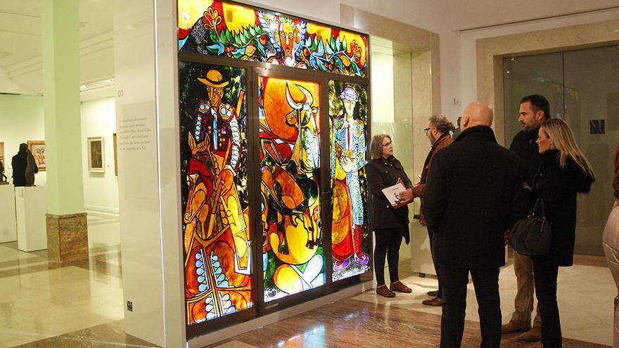 Varios visitantes  contemplan la vidriera de la Imprenta Belmar.