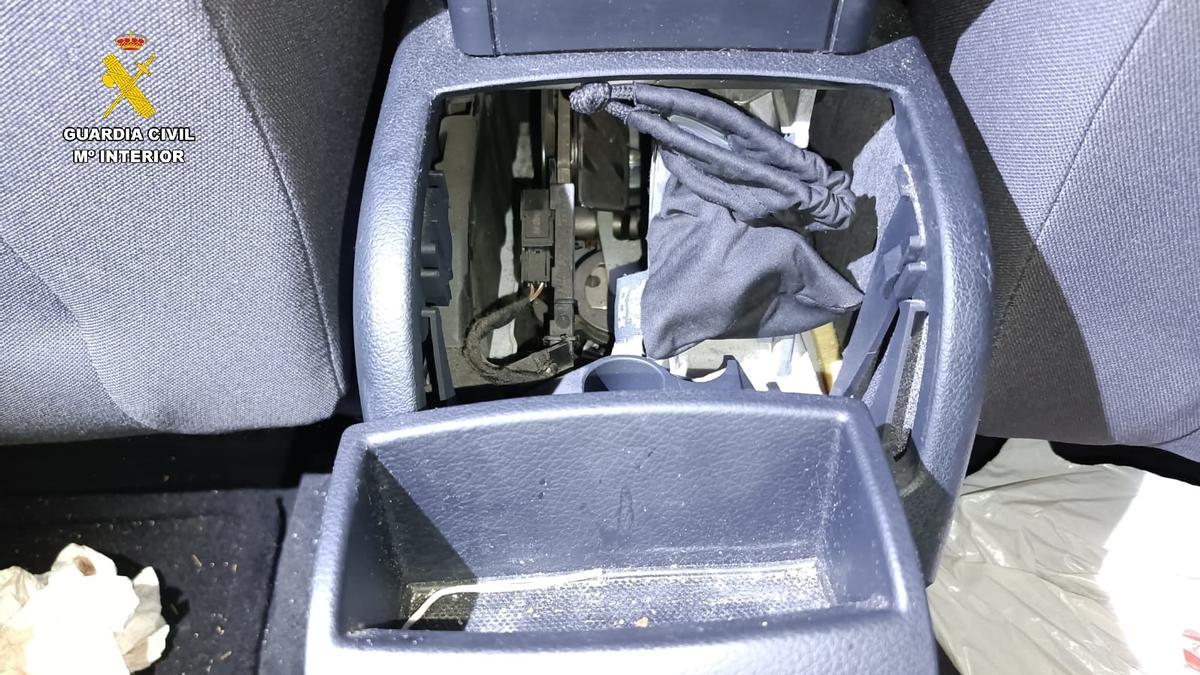 Cenicero del vehículo desmontado con la funda de gafas negra que escondía la droga.