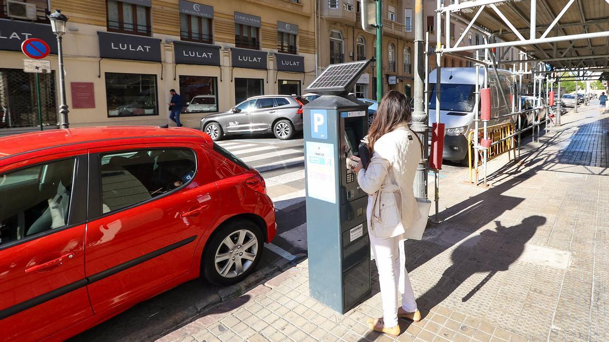 Una mujer compra el tiquet en uno de los parquímetros de la ORA.