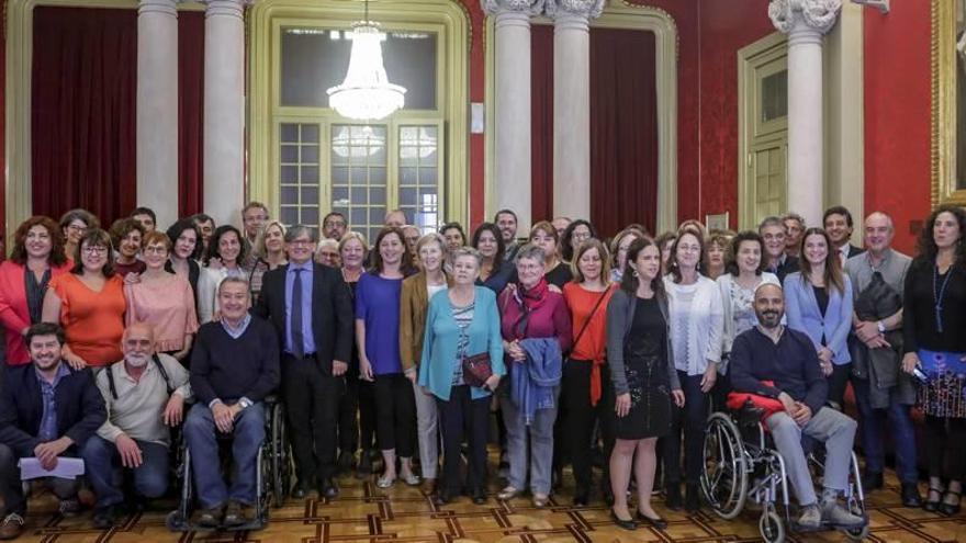 Diputados y representantes de las asociaciones, ayer en el Parlament.