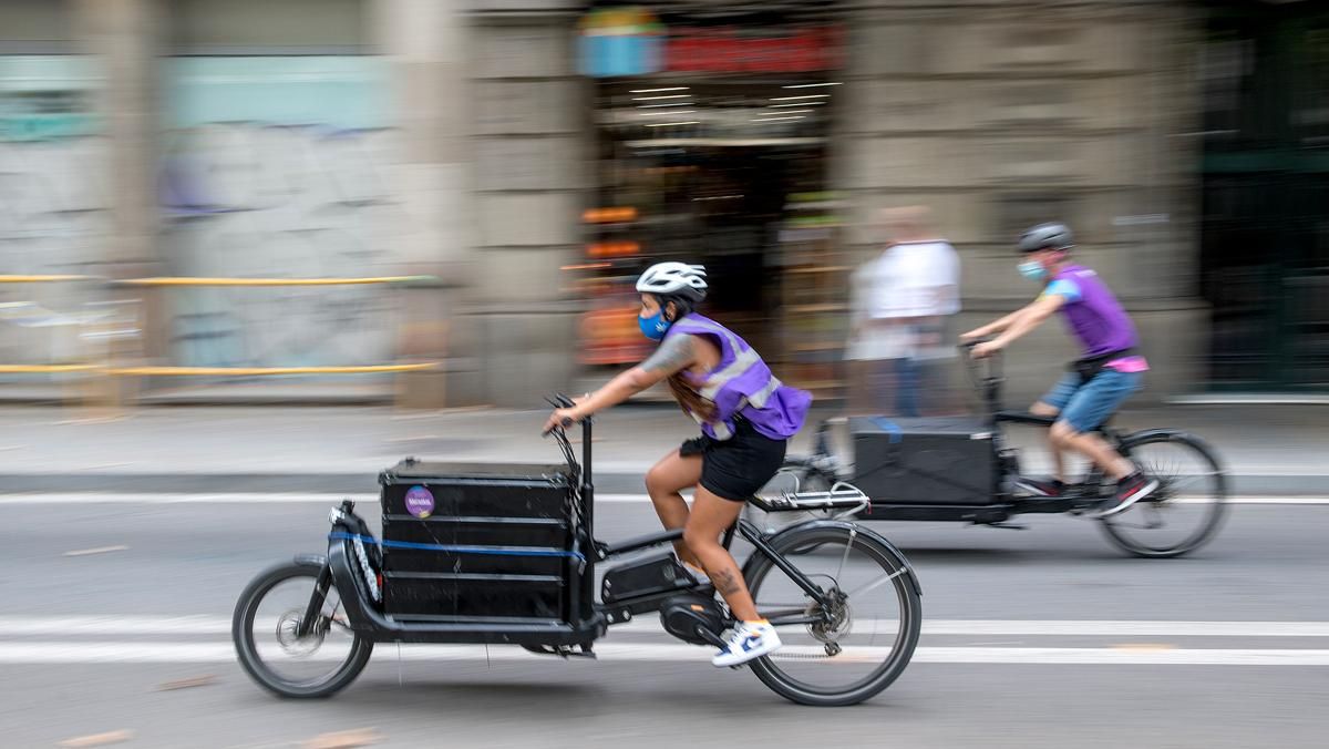 Dos 'riders' de Mensakas transportan un pedido, el pasado verano.