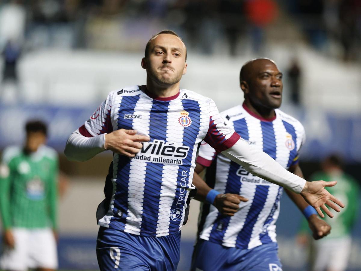 Santamaría, con Babin al fondo, señala el emblema de la camiseta tras anotarle un gol al Racing de Ferrol en el Suárez Puerta. | MIKI LÓPEZ