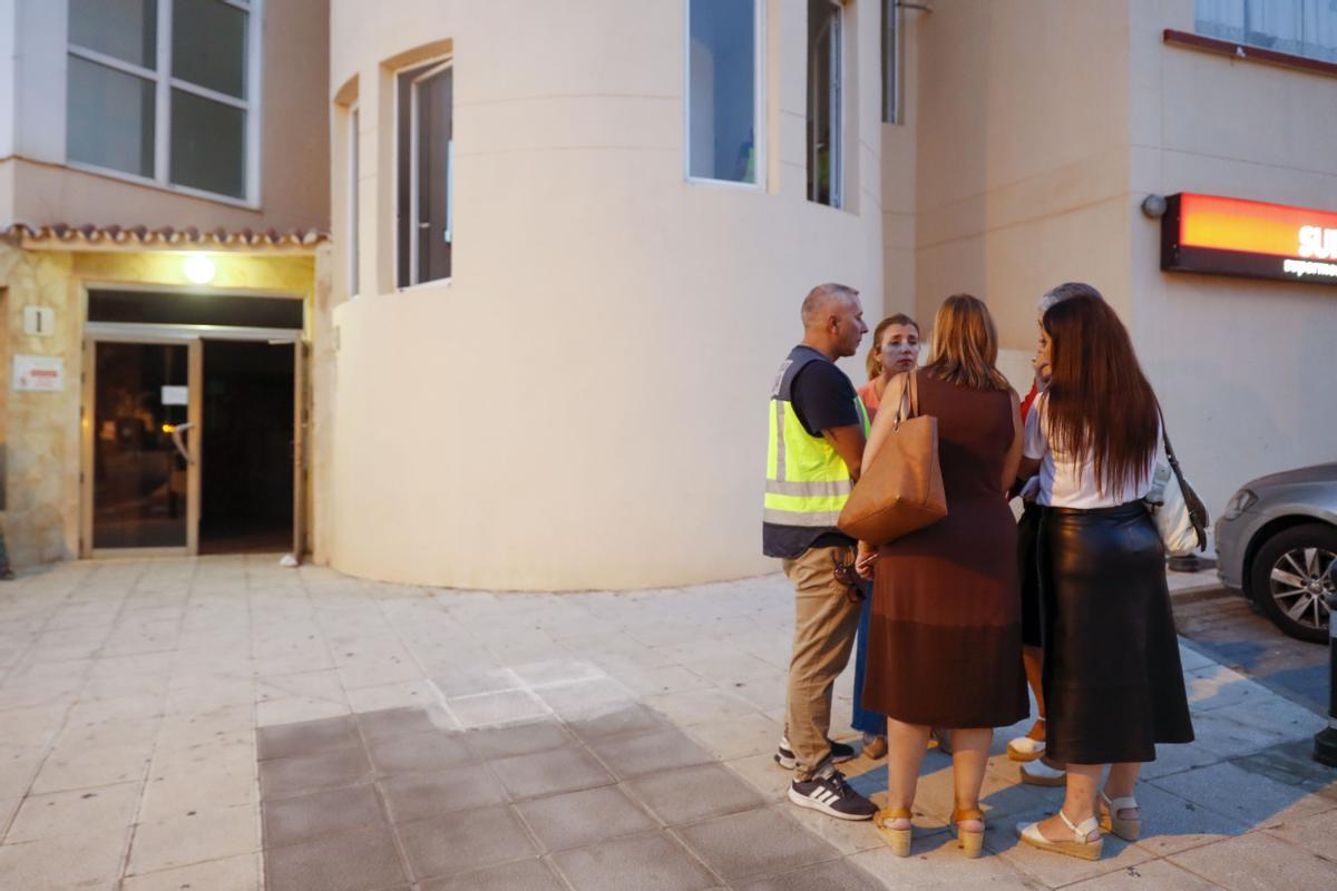 La policía científica habla con concejales de Málaga este martes, junto a la entrada del edificio donde han sido encontrados los cadáveres de un hombre y una mujer en Torrequebrada, Benalmádena.