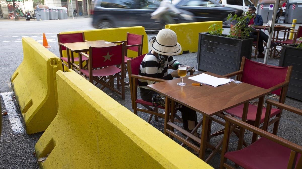  Vallas de hormigón pintadas de amarillo separan el lugar de lectura en el Bar La Crema  de la calle Diputacio 189 de la circulación de los coches, formando ya parte de la nueva normalidad provocada por el coronavirus