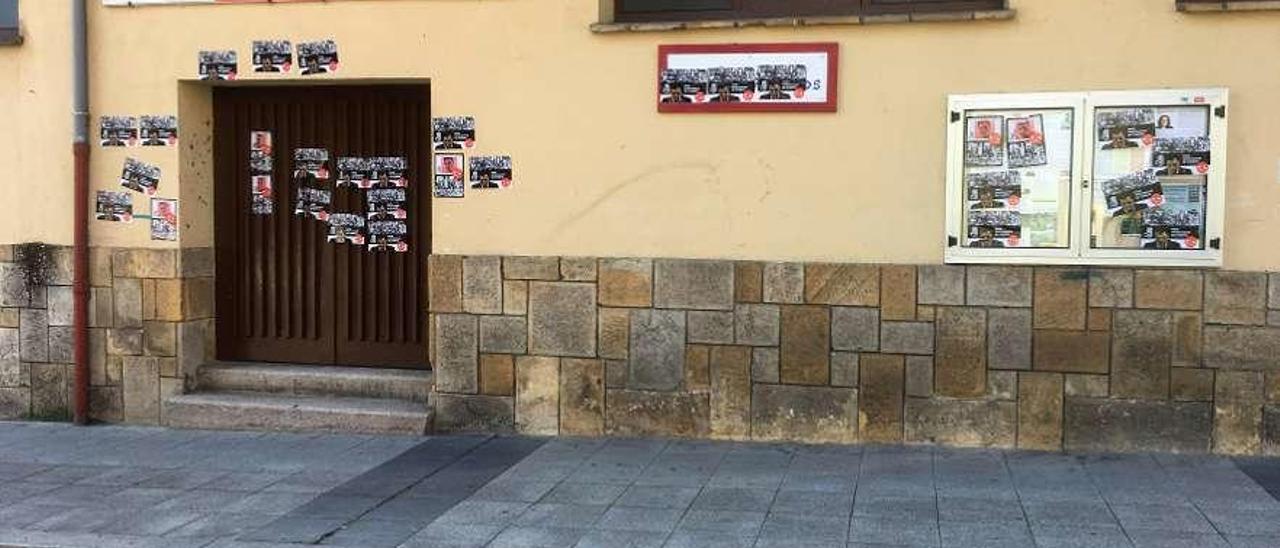 Un militante, entrando el viernes en la sede socialista en Langreo, empapelada con pasquines franquistas.