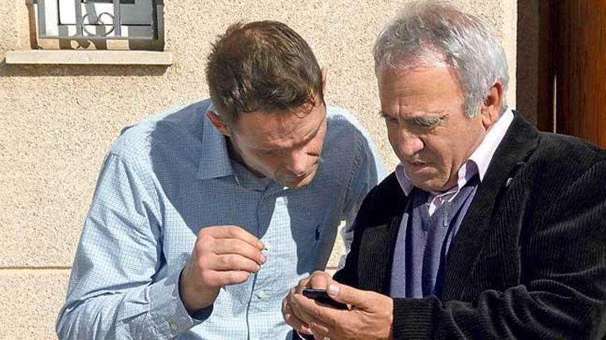 Romano y el padre Jaume Alemany con su nuevo teléfono móvil.