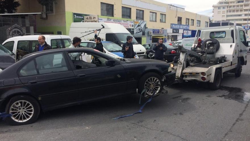 Una grúa retira un coche abandonado en el polígono industrial La Ermita. L. O.