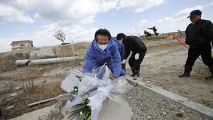 Un grup d’homes dipositen flors a Namie, a la prefectura de Fukushima.