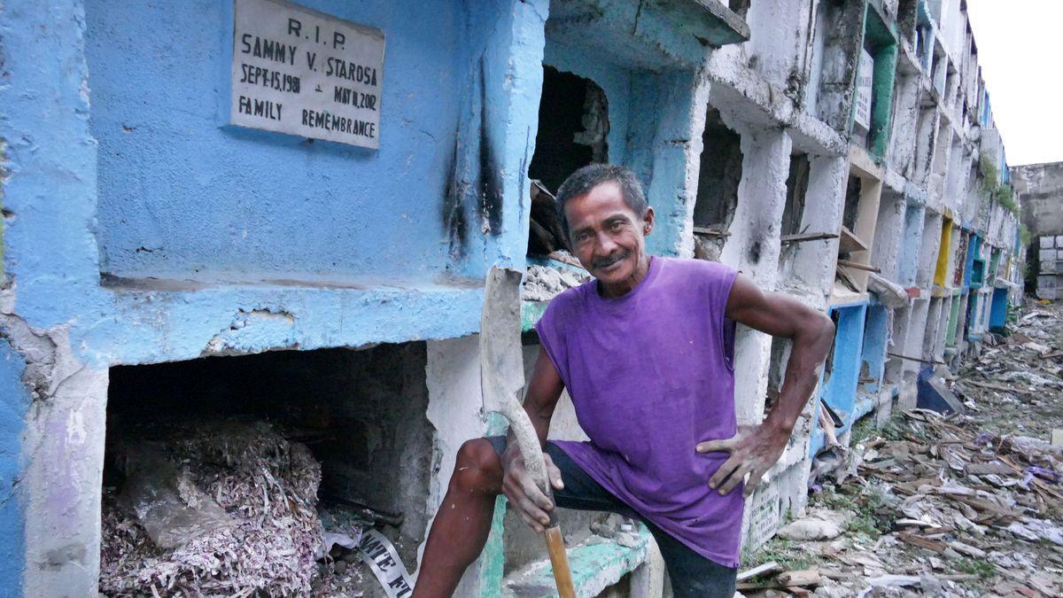 Uno de los trabajadores que se encarga de vaciar y limpiar los nichos de un cementerio de Manila.