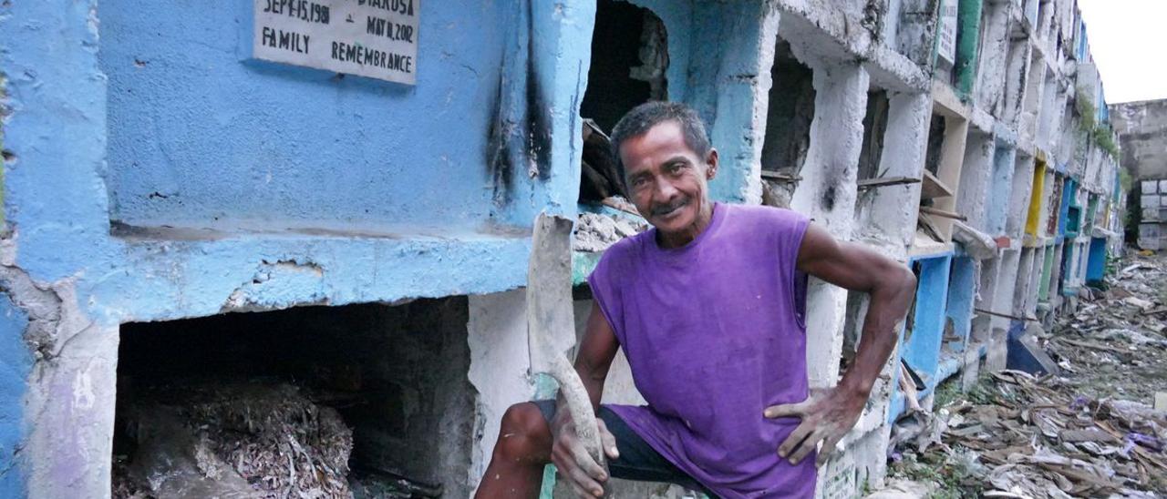 Uno de los trabajadores que se encarga de vaciar y limpiar los nichos de un cementerio de Manila.