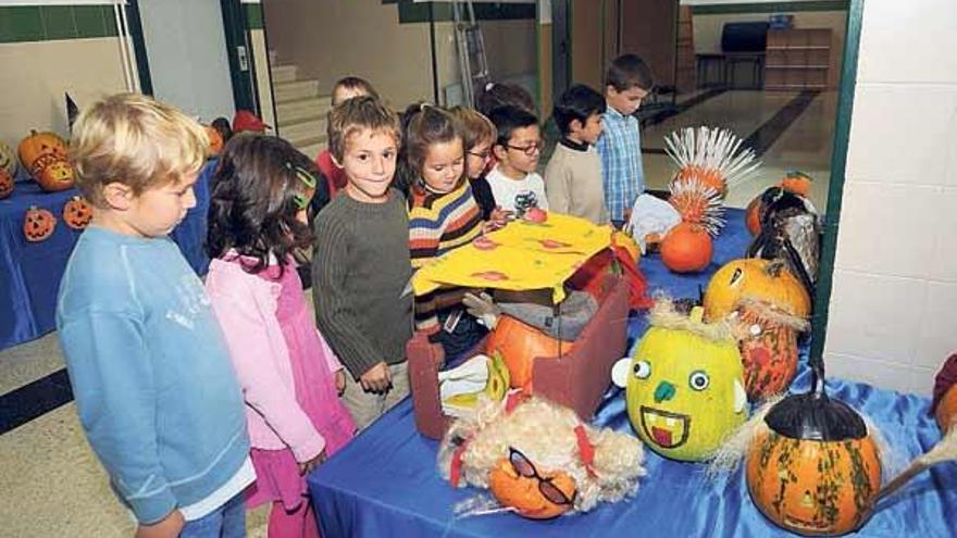 Alumnos del colegio de Xeve contemplan las calabazas decoradas que adornan estos días el centro.