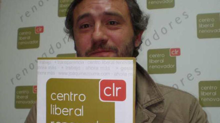 El miembro de CLr Julio Navarro muestra ambos logotipos.