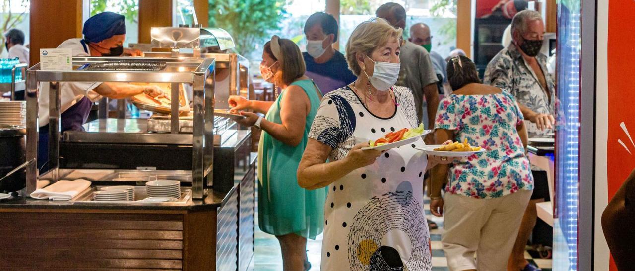 Un grupo de personas mayores se sirven a la hora de la comida en el bufé de un hotel de Benidorm, este otoño. | DAVID  NAVARRO