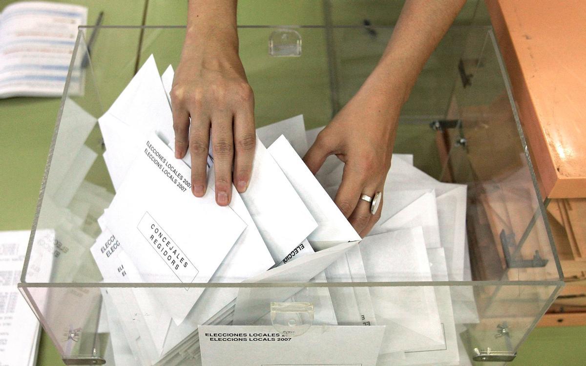 La presidenta de una mesa electoral coge una papeleta durante el recuento de votos La presidenta de una mesa electoral coge una papeleta durante el recuento de votos