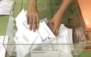 La presidenta de una mesa electoral coge una papeleta durante el recuento de votos