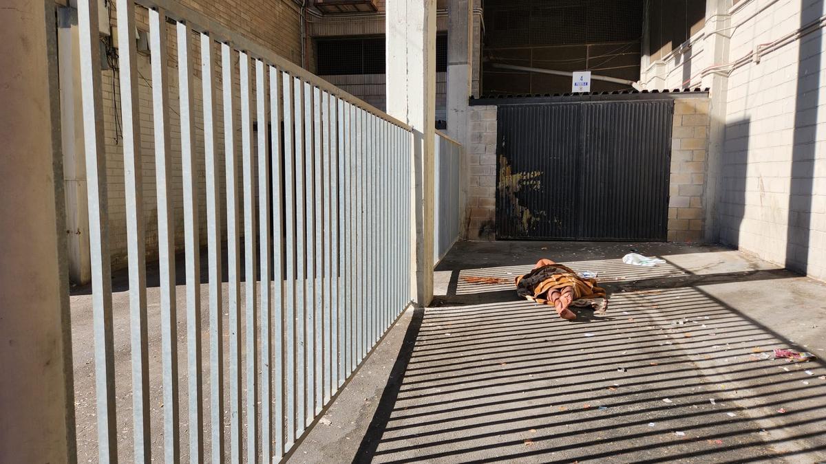 Una persona sin hogar durmiendo al raso junto a las taquillas del Rico Pérez y el nuevo vallado instalado por el club para evitar situaciones como esta