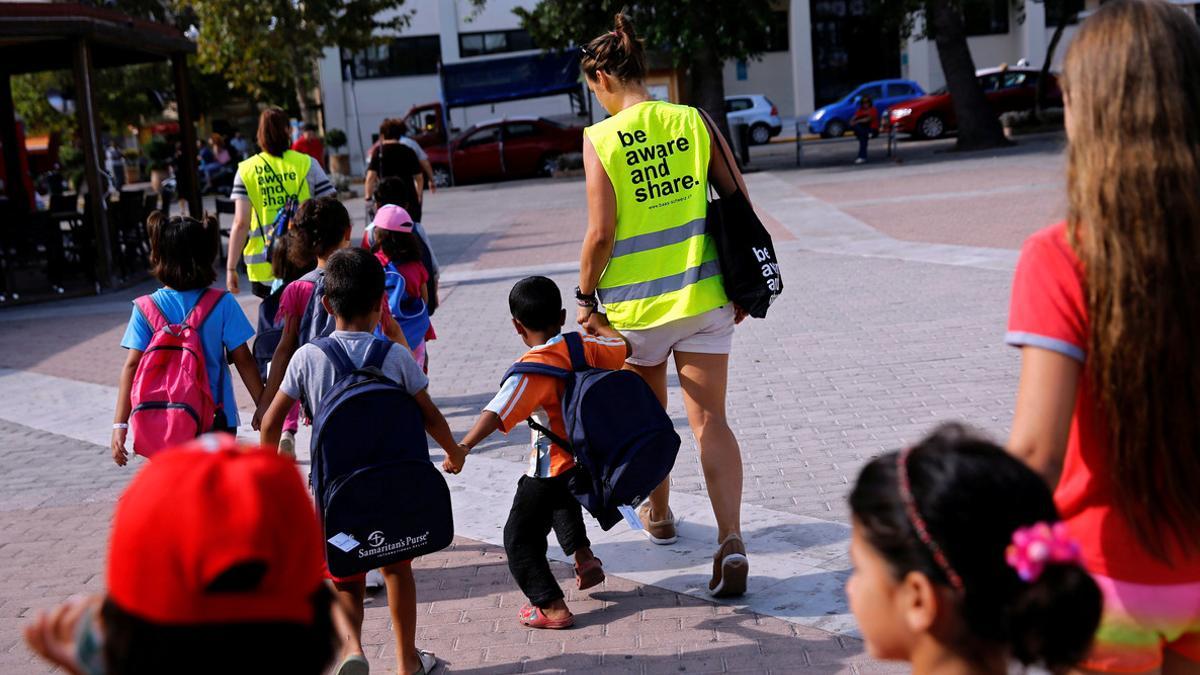 Volunteers escort refugee children at the volunteer-run &quot;Refugee Education Chios&quot; school on the island of Chios