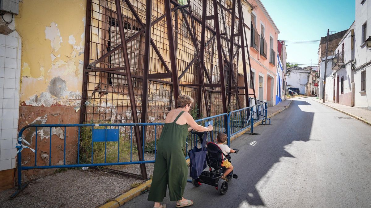 Una abuela baja a la calzada con su nieto para poder pasar por la calle Luis de Morales.