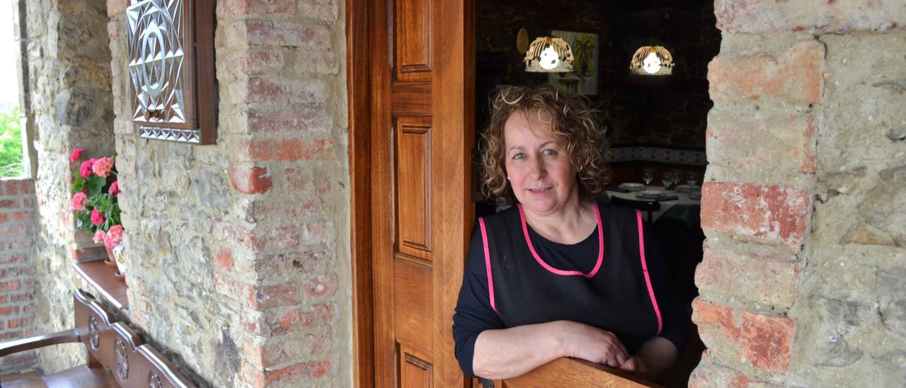 Agustina Fernández, asomada a la puerta de cuarterón de su restaurante en La Teyera, en el Cabo (Langreo)