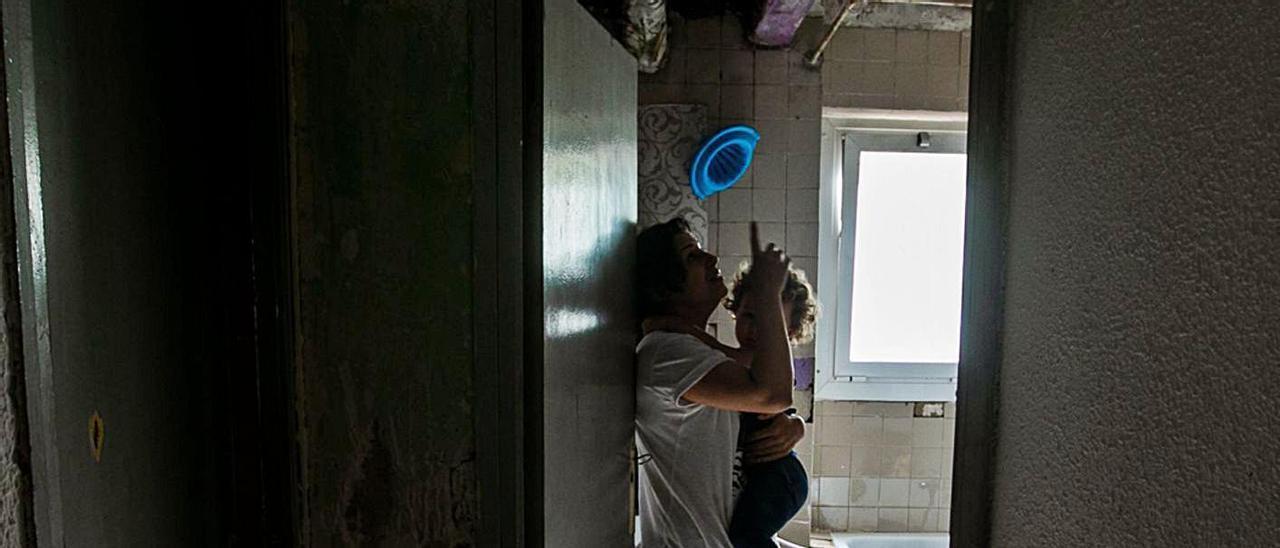 Fátima, con una de sus hijas, en su casa donde cortaron la luz hace unos días