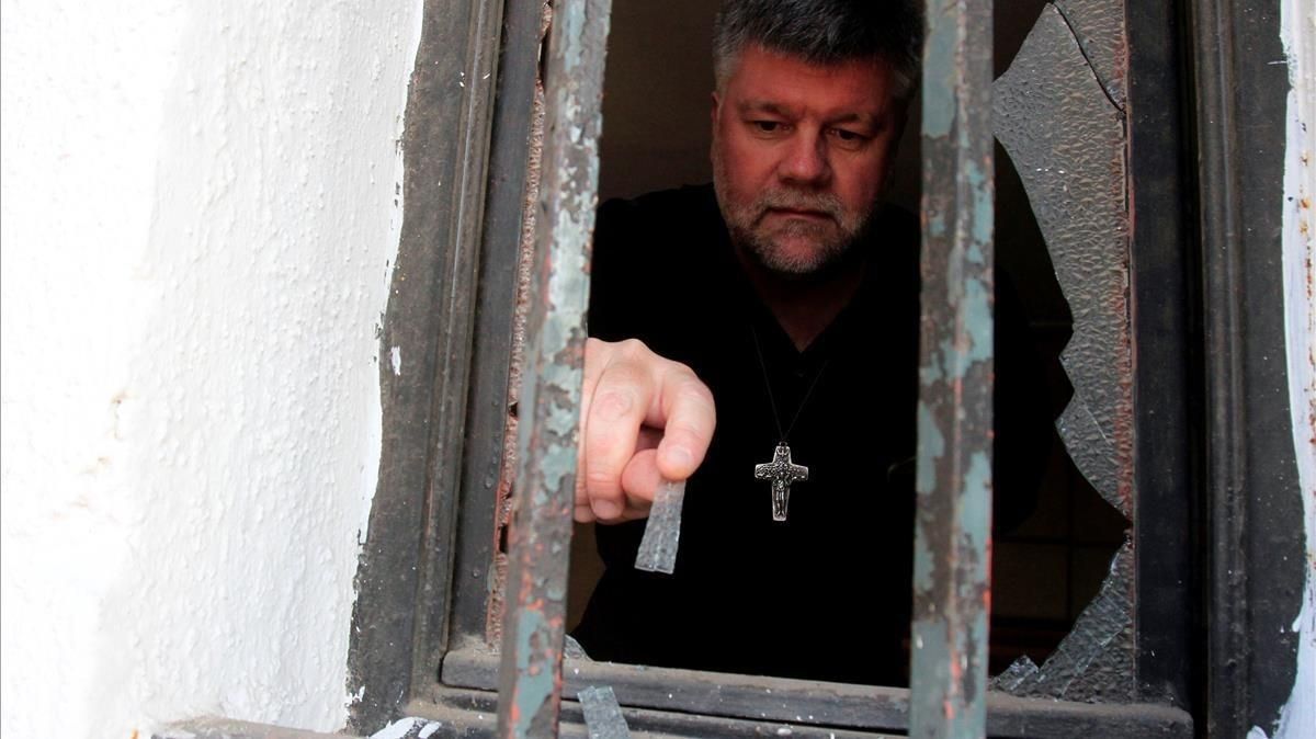 zentauroepp41573377 a man removes glass from a damaged window of a church that w180112182638