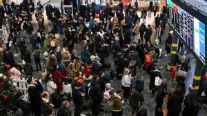 Ciudadanos esperando en la estación londinense de Euston a que salga su tren, en plena huelga en el día de Nochebuena. 