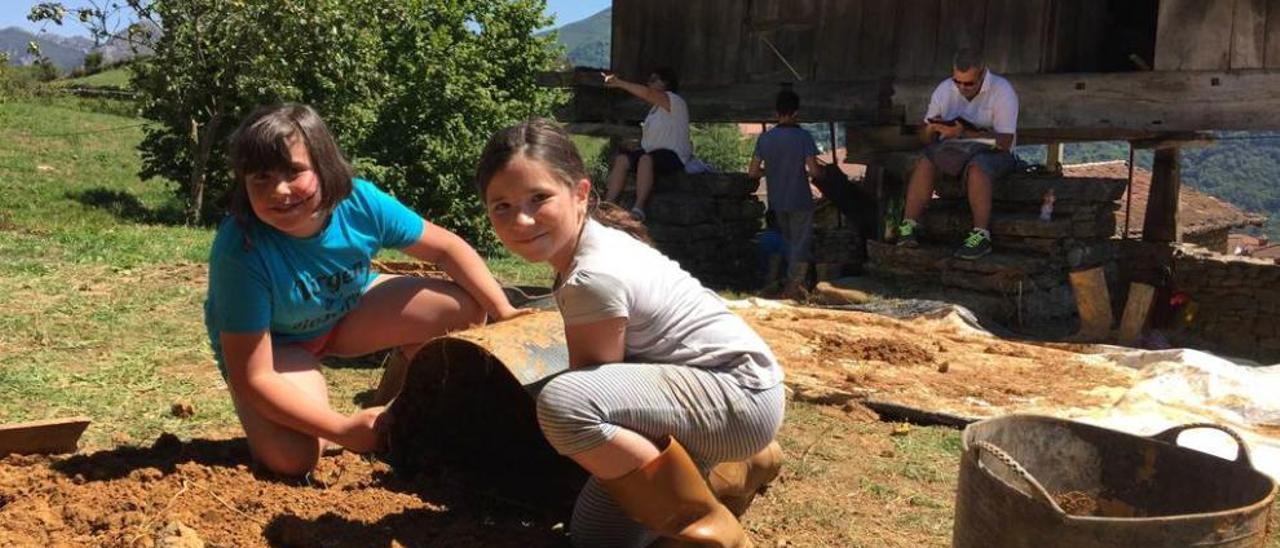 Sofía Rodríguez y Candela Ruipeláez preparan el barro para cubrir las paredes de la cabaña neolítica.