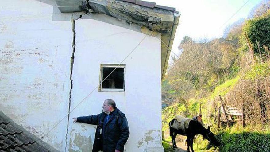 Manuel Siero señala una de las grietas que aparecieron en la fachada de su casa en Boo.