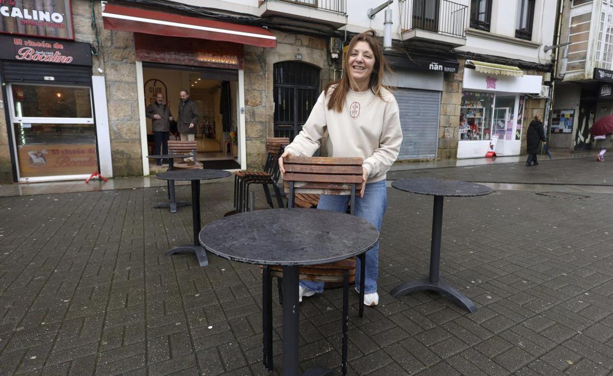 Fini Acuña, de «El Club del Café», coloca una silla ante su local. | GUSTAVO SANTOS