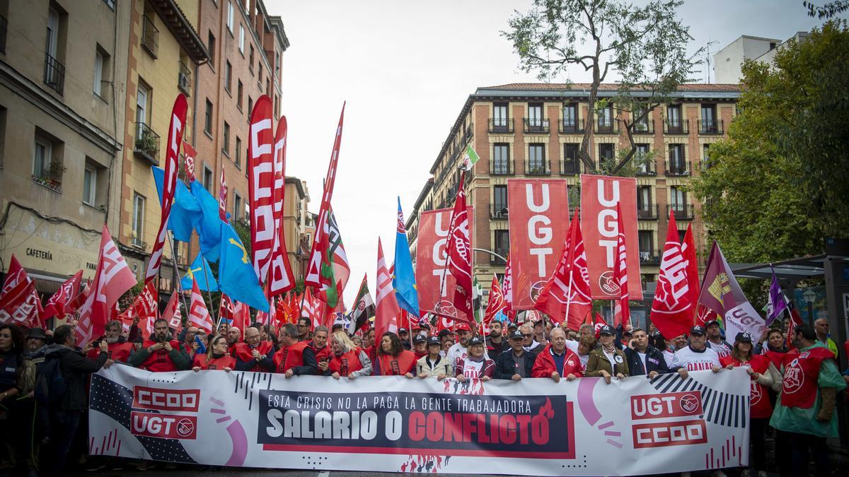 Centenares de personas sostienen banderas durante la movilización convocada por CCOO y UGT este jueves en Madrid.