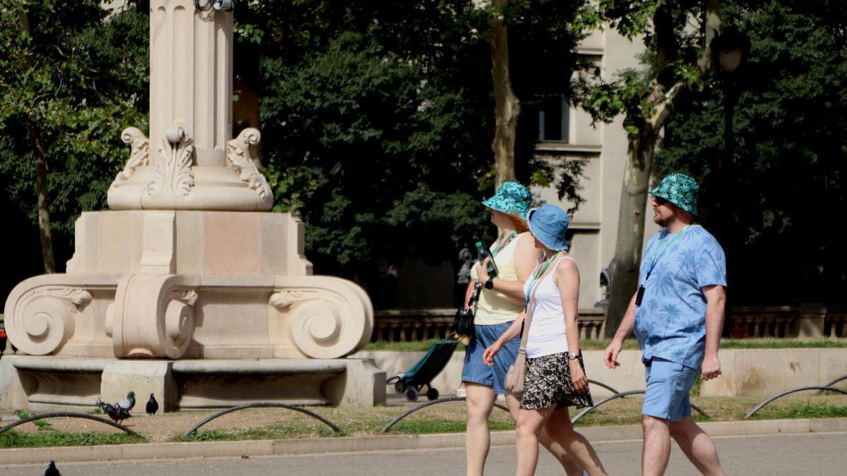 Els turistes es refugien de la calor amb gorres a Barcelona