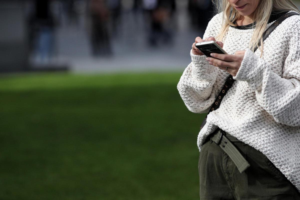 Una mujer utiliza su móvil, en Madrid a 18 de noviembre de 2019.