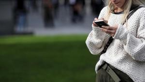 Archivo - Una mujer utiliza su móvil, en Madrid a 18 de noviembre de 2019.